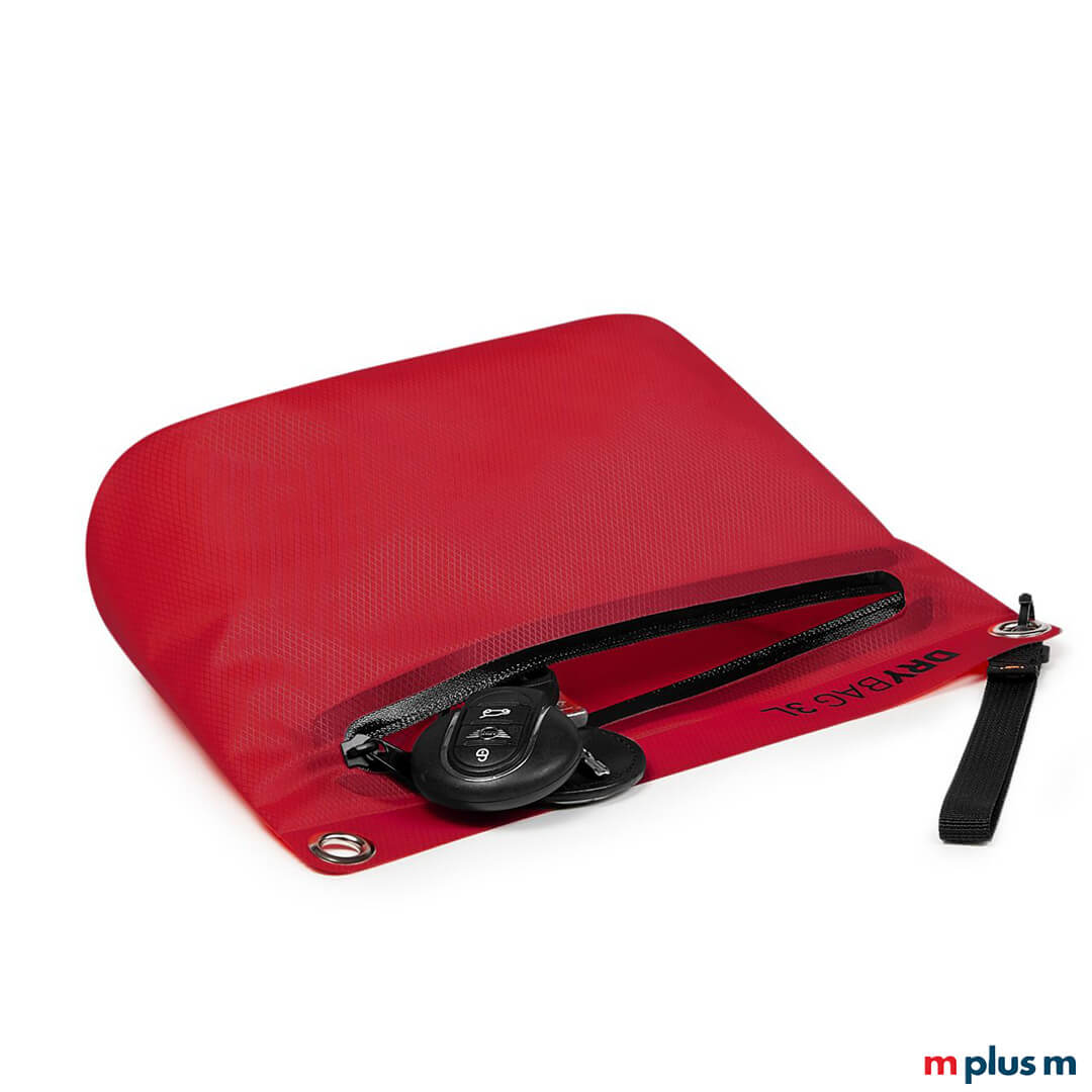 Rote 3L Drybag (wasserdichte Tasche) von Halfar, halb geöffnet, zeigt eine innenliegende Autoschlüssel-Fernbedienung in der Reißverschlusstasche. Oben links ist eine Metallöse sichtbar.